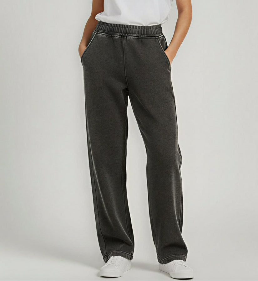 Person wearing dark gray wide-leg pants on a light gray background